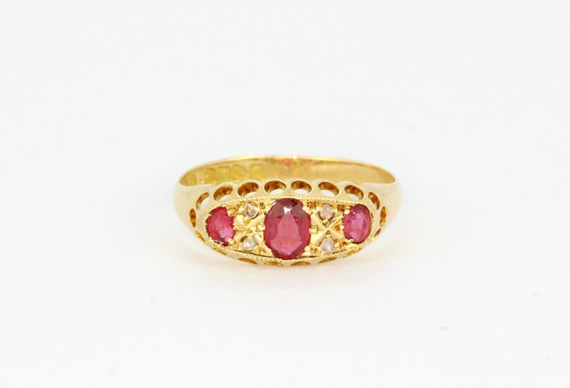 An antique 18ct yellow gold ring set with oval cut rubies and old cut diamonds, (N).