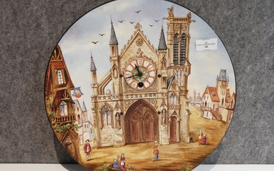 Assiette horloge décorative en faïence polychrome à décor d’une place d’église animée. Dima. : 37cm....