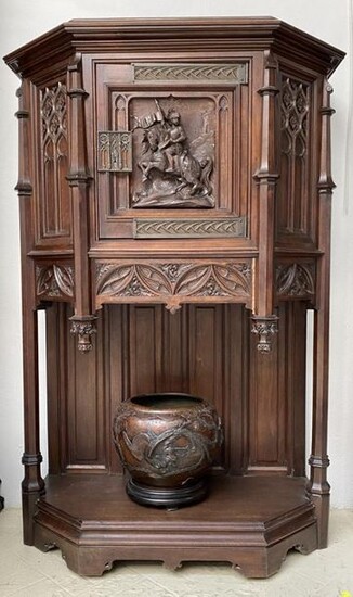 CREDENCE in carved walnut in medieval style resting on a base with cut sides and panelled backsplashes. Two columns support a body carved with arcatures and opening through a door decorated with a knight. The hinges and lock entries are in silvered...