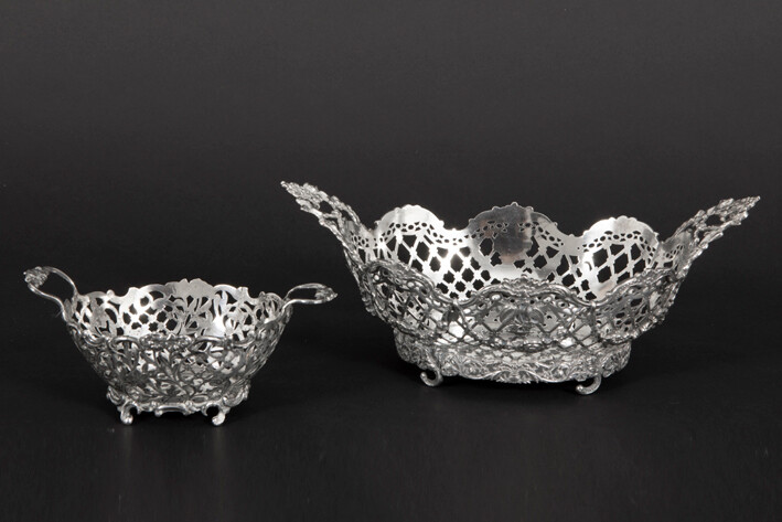 Lot (2) of a beautiful antique flower basket with two handles and with an annouated curb in marked solid silver (width : 25,2 cm - weight : 406 grams) and a cute praline basket with handles and annouated curb in marked solid silver (weight : 406 grams).