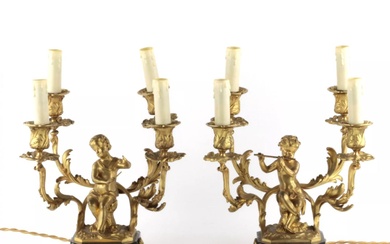 Paired lamps of gilded bronze with cupids playing music.