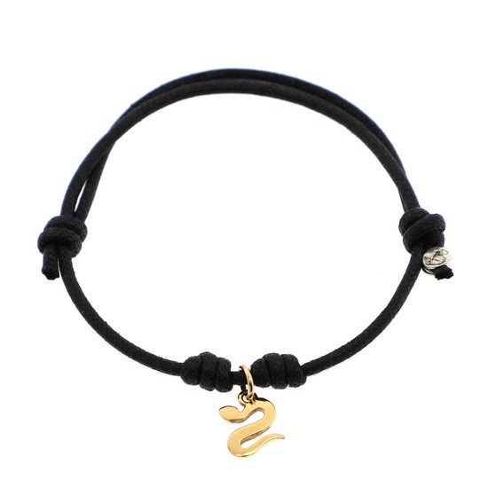 Pomellato: A “Dodo” pendant in shape of a snake of 18k gold, mounted on an adjustable black cotton string.