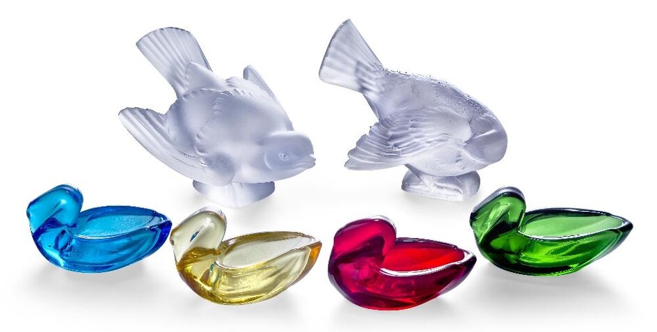 Two modern Lalique style glass birds, one preening its feathers, the other with spread wings, each bearing signature to the base Lalique France, 12cm and 11cm wide; together with four modern coloured glass swans, 7cm wide (6)