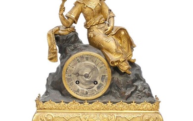 A Charles X gilt and patinated bronze table clock adorned with seated...