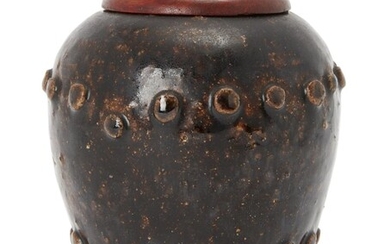A Chinese stoneware ovoid water pot, Ming dynasty, covered in a brown glaze, decorated with two studded bands raised on three short feet, later wood cover, 11cm high 明 醬釉骨釘紋三足罐連木蓋