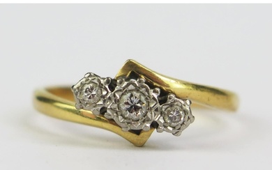 A Diamond Three Stone Crossover Ring in a precious yellow an...