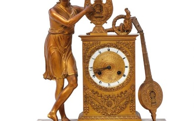 A French Empire mantel clock of gilt bronze, the case adorned with...