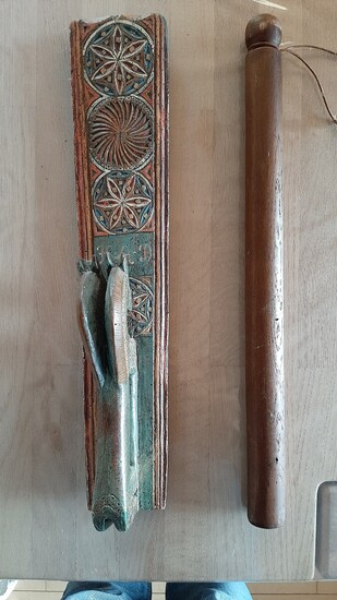 A carved mangleboard with horse handle and a roler. 19th century. L. 90 cm. (2)