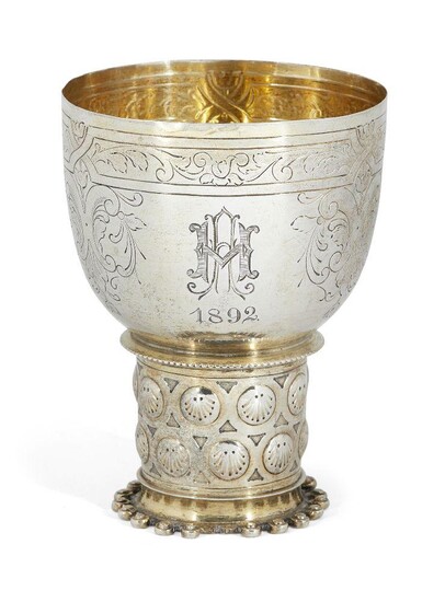 A nineteenth century small German silver cup, designed as a copy of a 17th century Dutch drinking vessel, the cylindrical stem to foot with decorative surround, the gilded cup engraved with leaf and scroll decoration to monogram dated 1892, 9cm...