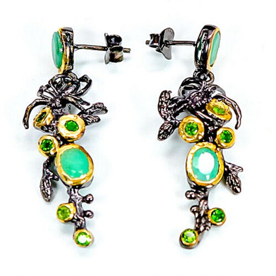 A pair of ear pendants each set with nummerous oval and circular-cut emeralds and chrome diopsides, mounted in black rhodium and gold plated sterling silver.