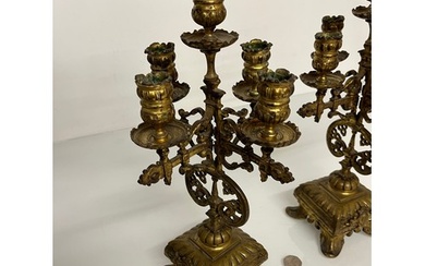 A pair of ornate cast brass four branch candlelabras. This...