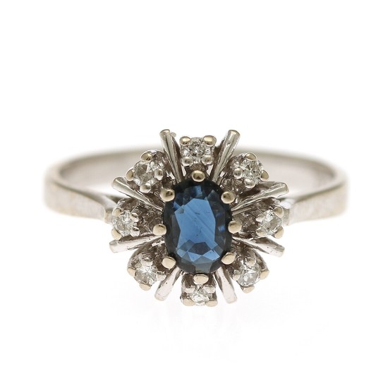 A sapphire and diamond ring set with an oval-cut sapphire encircled by eight brilliant-cut diamonds, mounted in 14k white gold. Size 53.5.