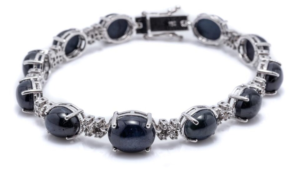 AN 18CT WHITE GOLD SAPPHIRE AND DIAMOND BRACELET; composed of 11 links each set with a cabochon blue star sapphire united by 10 clus...