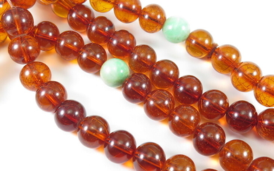 AN AMBER-COLOUR FLAPPER-BEAD NECKLACE WITH JADE SPACER BEADS