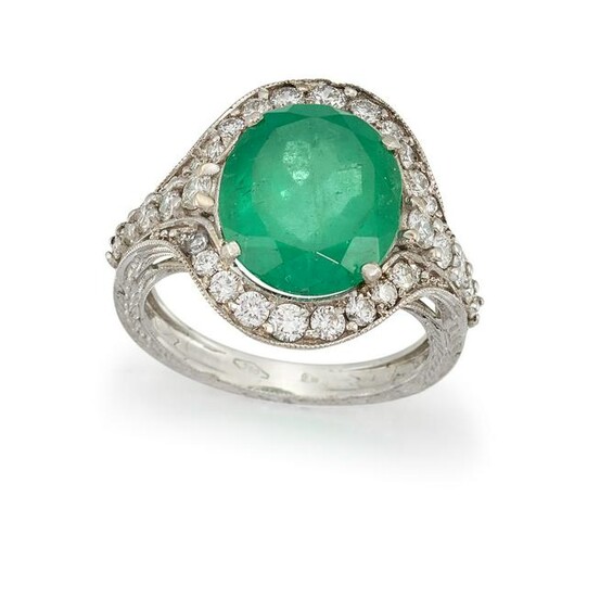 AN EMERALD AND DIAMOND CLUSTER RING The oval-cut