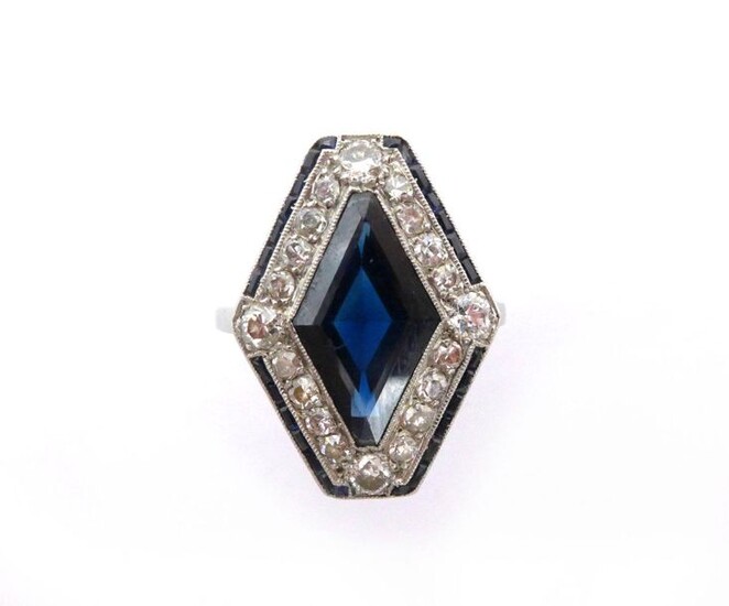 ART DECO RING in platinum, the basket with a foliage design, centred on a diamond-shaped sapphire, in a ring of diamonds (8/8 and antique cut) and calibrated sapphire lines. French work. Original case. TDD: 51. Gross weight : 4.50 gr. A sapphire...