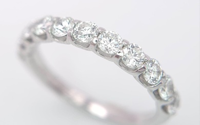 An 18 K white gold half eternity ring with...
