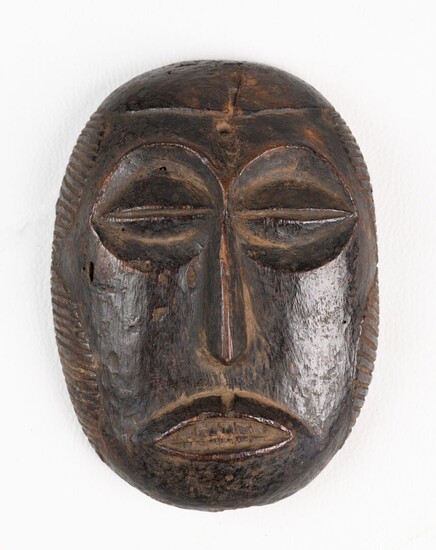 BEMBE R.D.CONGO Petit masque en bois à belle patine brun foncé. Une étiquette au verso...