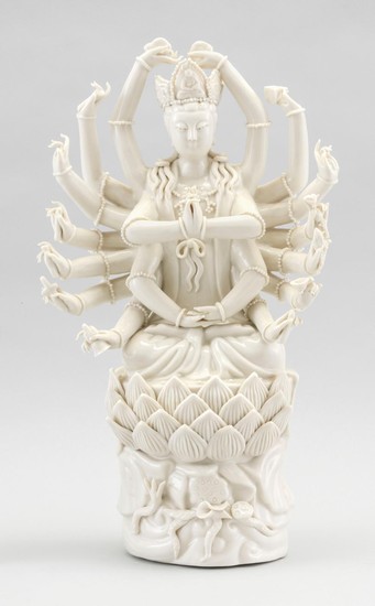 CHINESE BLANC DE CHINE PORCELAIN FIGURE OF A THOUSAND-ARM GUANYIN Seated in prayer on a lotus throne and holding various items in he...