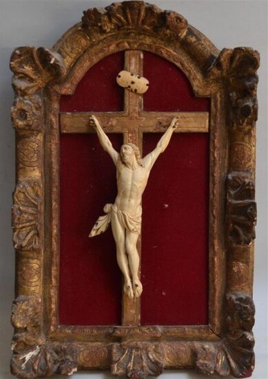 CHRIST en ivoire sculpté avec titulus, monté sur une croix inscrite dans un cadre en bois sculpté et doré