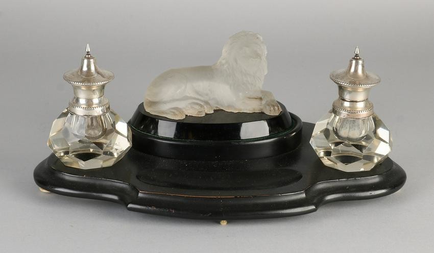 Ink set on wooden base, features a glass reclining lion
