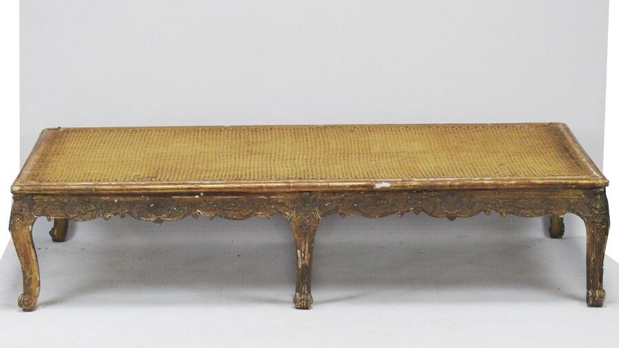 Resting bed made of wood carved on three sides and gilded with shells and scrolls decoration. Rectangular in shape, it rests on six legs with windings.