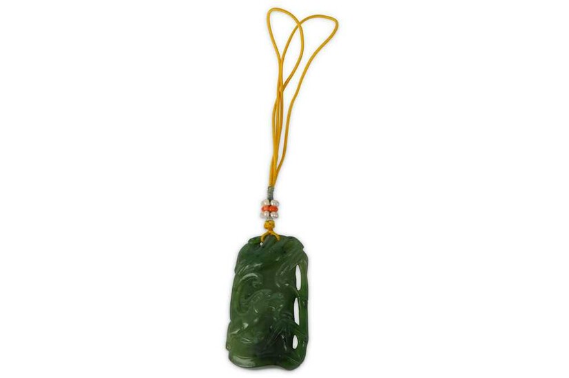 A CHINESE SPINACH-GREEN JADE ‘DRAGON ON BAMBOO’ PENDANT. Carved...