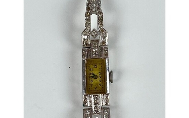 1930. Montre de dame en platine. Boîtier rectangulaire et attaches géométriques ornées de diamants. Bracelet...