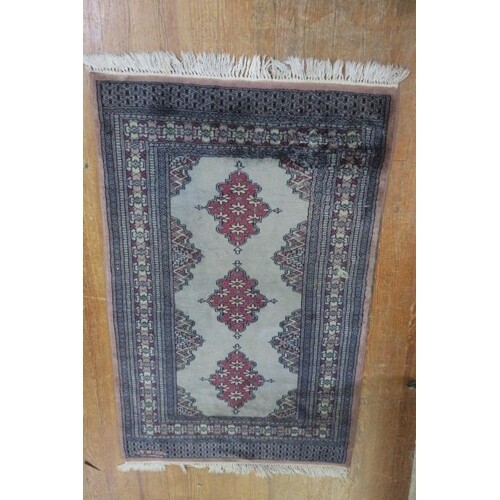 A BUKHARA WOOL RUG the light blue ground with three central ...