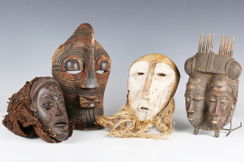 A Baule carved wooden twin mask, Ivory Coast, finely modelled and painted with two faces with woven