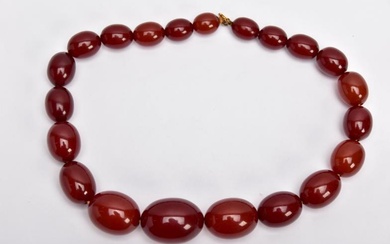 A CHERRY AMBER GRADUATED BEAD NECKLACE, the largest measuring...