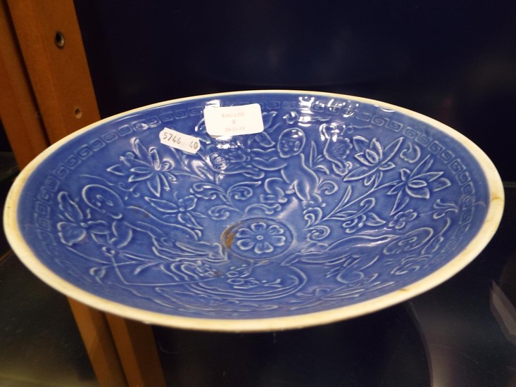 A Chinese blue glazed bowl decorated with figures amongst bl...