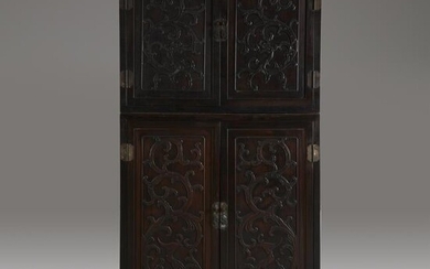 A Chinese carved hardwood two-part compound cabinet