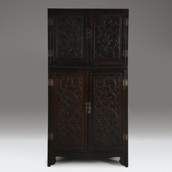 A Chinese carved hardwood two-part compound cabinet