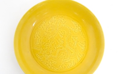 A Chinese dish with a yellow ground decorated with dragons a...