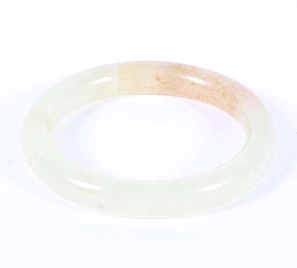 A Chinese jade bangle of mottled pale yellow-green colour