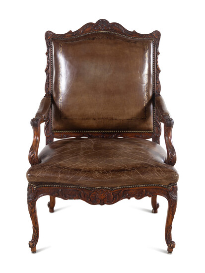 A Régence Style Carved Walnut Fauteuil with Leather Upholstery