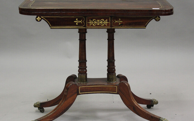 A Regency rosewood and brass inlaid fold-over card table, raised on twin columns and sabre legs, hei