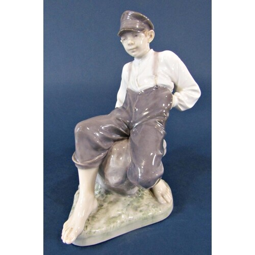 A Royal Copenhagen model of a seated boy, marked to base 165...