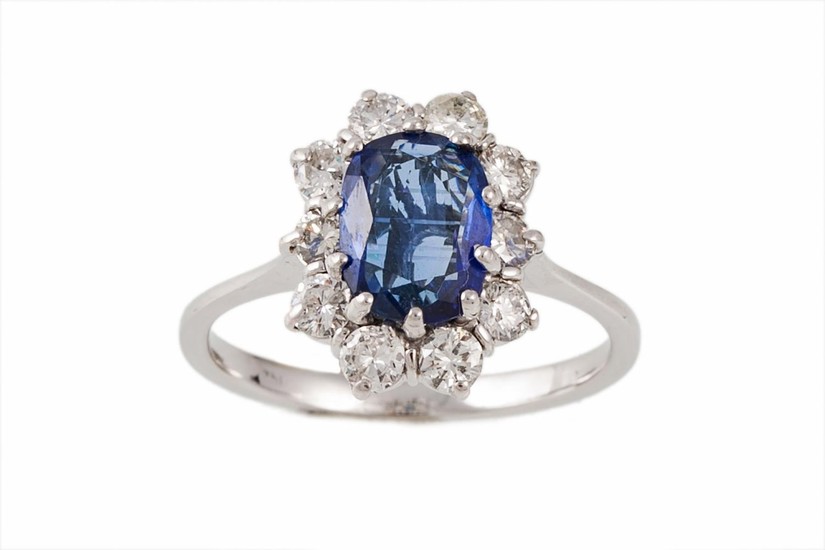 A SAPPHIRE AND DIAMOND CLUSTER RING, the oval sapphire weigh...