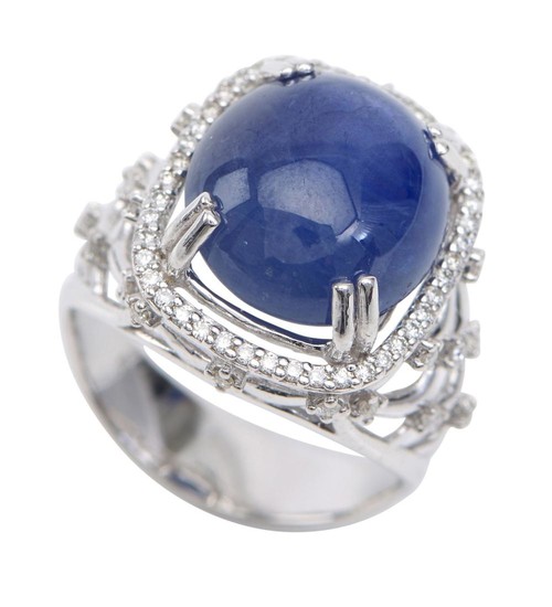 A STAR SAPPHIRE AND DIAMOND RING - The oval cut sapphire weighing 13.3cts, with diamonds set to the shoulders and surround totalling...