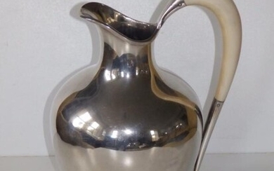 A Sterling silver pitcher, of plain design with ivory...