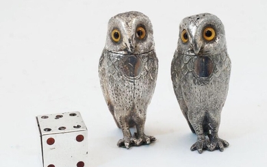 A Victorian novelty silver and enamelled pepper shaker in the form of a die, London, 1889, Thomas Johnson II, 2.5cm x 2.5cm; together with two novelty silver plated peppers in the form of owls, with coloured glass eyes, 8cm high (3)