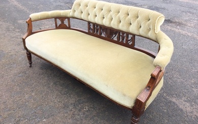 A Victorian walnut sofa with button upholstered back and rounded...