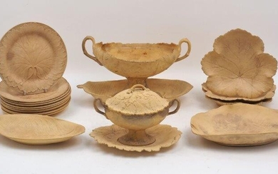 A collection of Wedgwood caneware, mid to late 19th century, relief moulded with leaf and vine forms and motifs, all pieces incised WEDGWOOD and with date letters, to include a twin handled centerpiece, 18.5cm high, with associated saucer, 34cm...