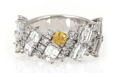 A diamond ring set with a radiant- and trapeze-cut diamond and numerous...