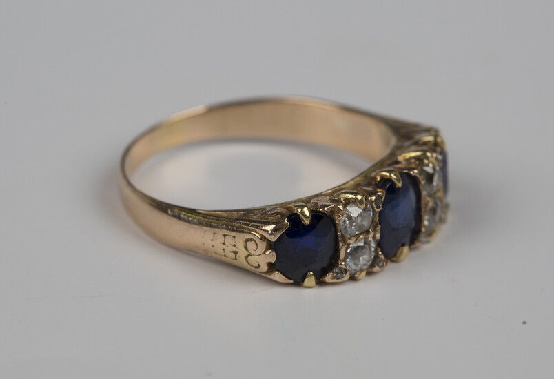 A gold, sapphire and diamond ring, mounted with three oval cut sapphires and two pairs of cushion sh
