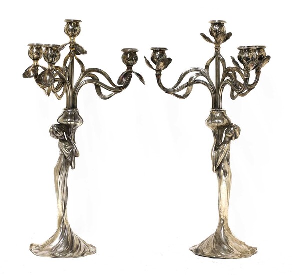 A matched pair of WMF silvered four-branch figural candelabra