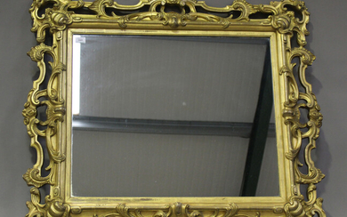 A mid/late Victorian carved gilt wood and gesso framed wall mirror, decorated with leaf and 'C&