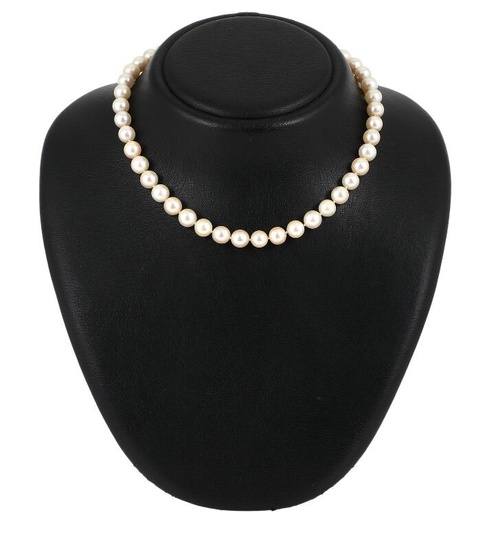 A pearl necklace set with numerous Akoya cultured pearls and a clasp...